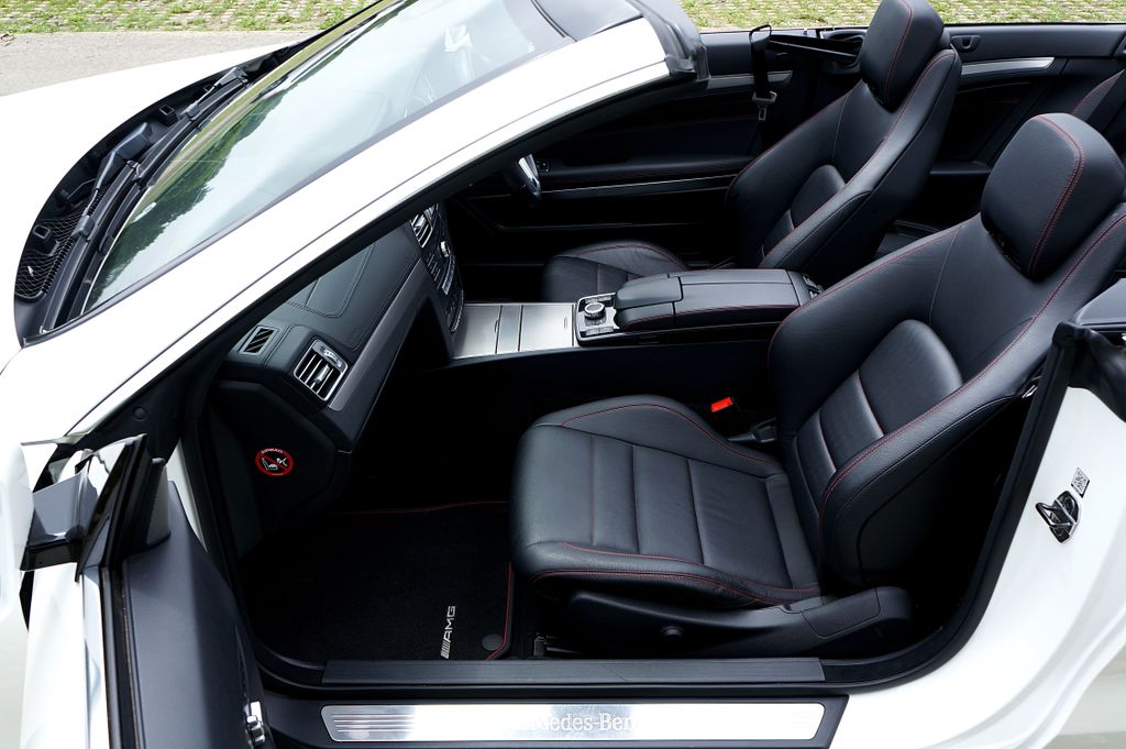 Explore the sleek black leather interior of a luxury convertible sports car parked in the UK.